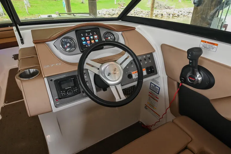 Slide: The Image of 2016 Sea Ray 270 Sundeck dashboard with steering wheel and control panel. - 28