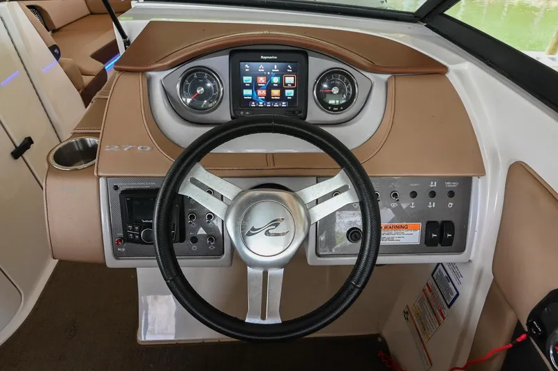 Slide: The Image of 2016 Sea Ray 270 Sundeck dashboard with steering wheel and control panel. - 29