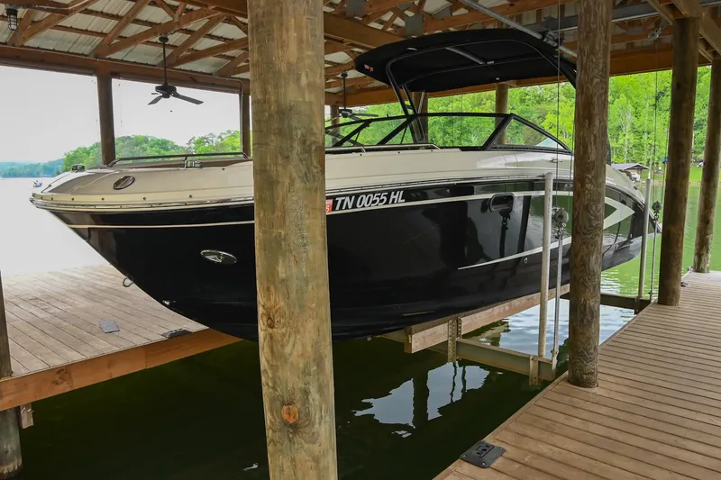Slide: The Image of 2016 Sea Ray 270 Sundeck boat docked under a wooden shelter. - 3