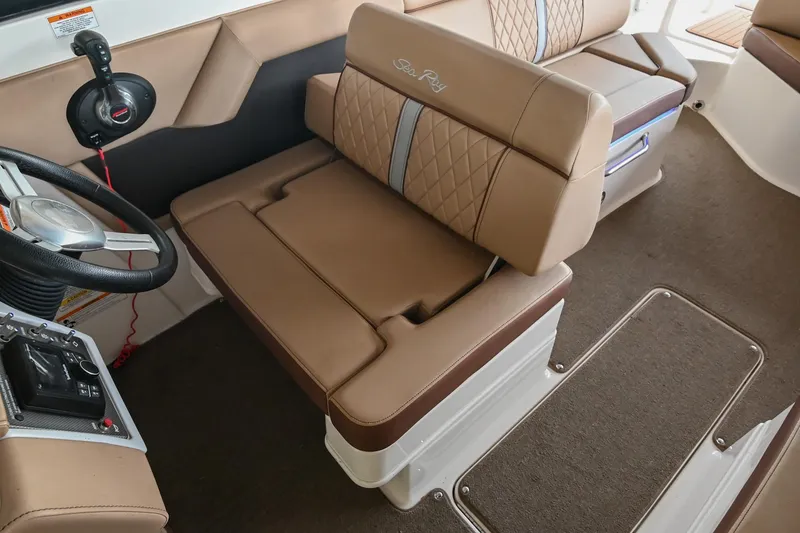 Slide: The Image of 2016 Sea Ray 270 Sundeck interior with tan seating and steering wheel. - 30