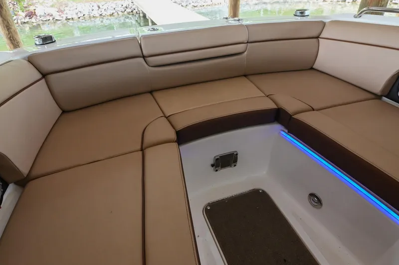 Slide: The Image of 2016 Sea Ray 270 Sundeck interior with tan seating and blue LED lighting. - 37