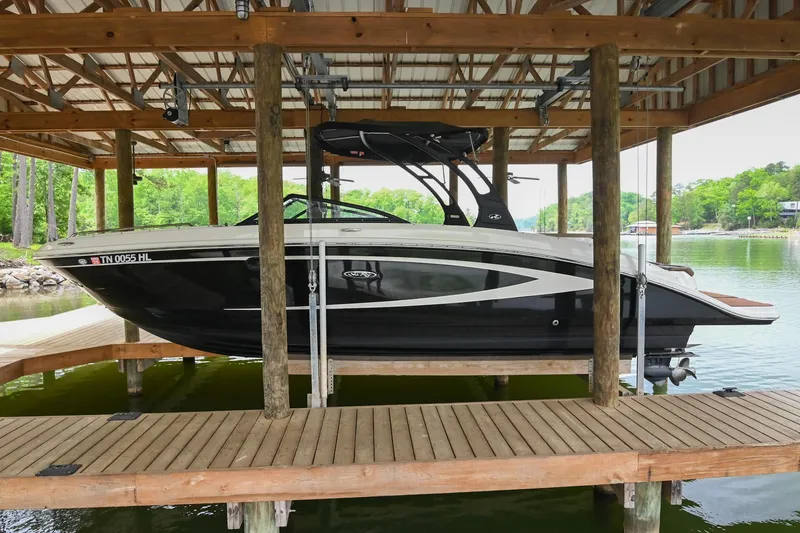 Slide: The Image of 2016 Sea Ray 270 Sundeck boat docked under a wooden shelter by the lake. - 4