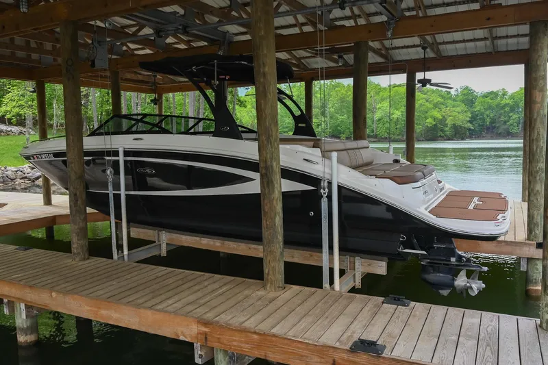 Slide: The Image of 2016 Sea Ray 270 Sundeck boat docked under a wooden shelter. - 5