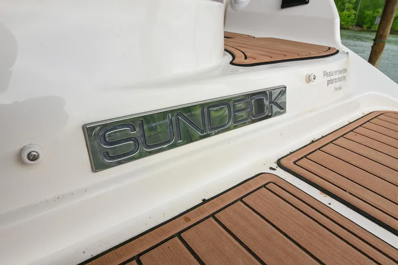 Slide: The Image of 2016 Sea Ray 270 Sundeck boat with teak-style decking and "Sundeck" emblem. - 8