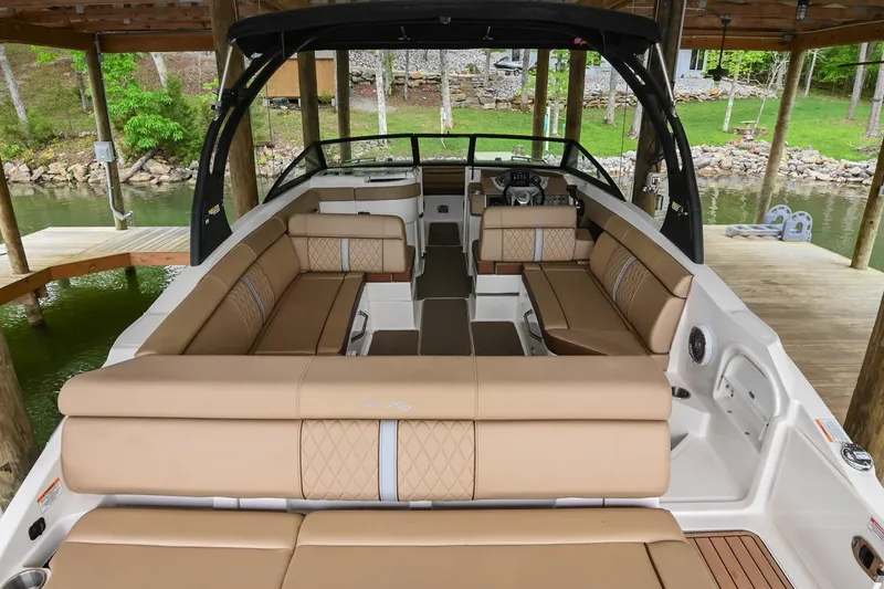 Slide: The Image of 2016 Sea Ray 270 Sundeck boat with spacious tan seating under a wooden dock. - 9