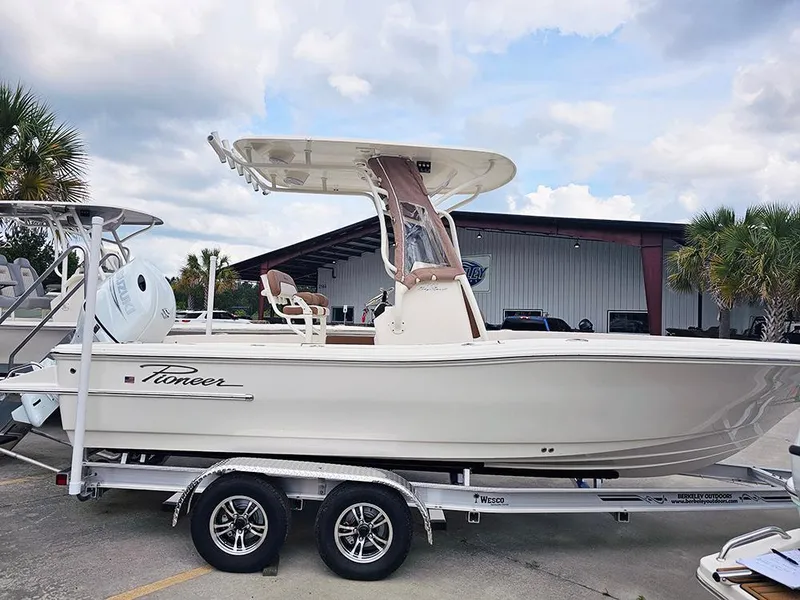 The Image of 2025 Pioneer 220 Bay Sport boat on trailer, parked outdoors near a building. - 1