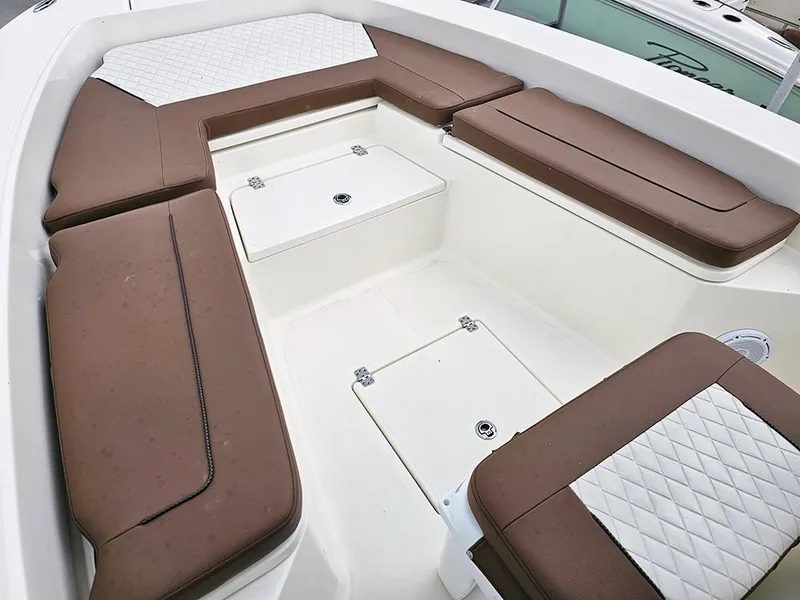 Slide: The Image of 2025 Pioneer 220 Bay Sport boat interior with brown cushioned seating and white accents. - 17