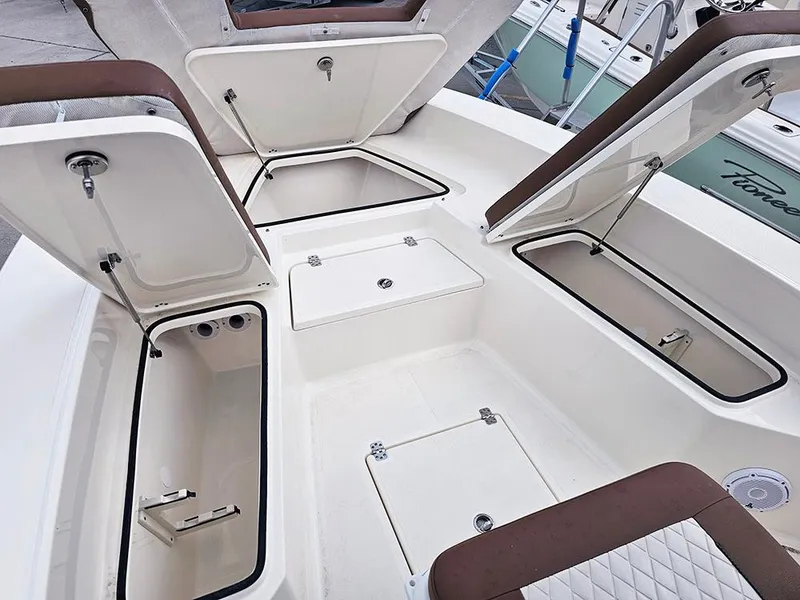 Slide: The Image of 2025 Pioneer 220 Bay Sport boat storage compartments open, showcasing spacious interior design. - 19