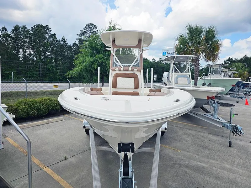 Slide: The Image of 2025 Pioneer 220 Bay Sport boat on trailer, parked outdoors with trees in background. - 4