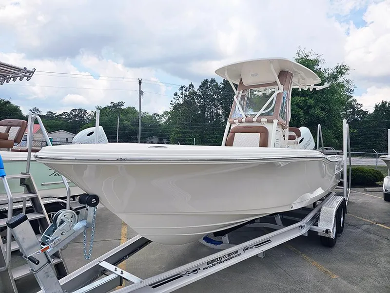 Slide: The Image of 2025 Pioneer 220 Bay Sport boat on trailer, displayed outdoors under cloudy sky. - 5