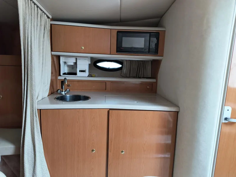 Slide: The Image of 2001 Regal Commodore 3260 boat kitchenette with sink, microwave, and storage cabinets. - 10