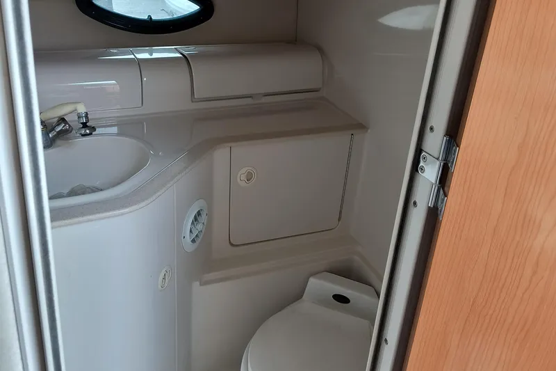 Slide: The Image of 2001 Regal Commodore 3260 boat bathroom with sink, toilet, and storage cabinet. - 19