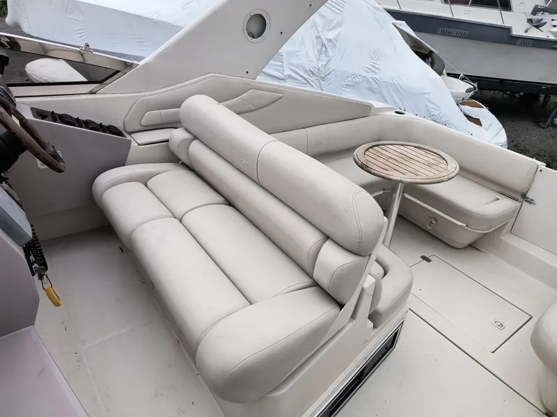 Slide: The Image of 2001 Regal Commodore 3260 boat interior with beige seating and small wooden table. - 5