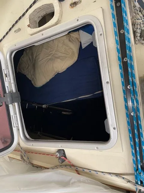 Slide: The Image of Open hatch on 2003 Herreshoff 42 sailboat, revealing interior with bedding. - 11