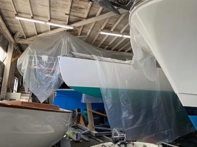 Slide: The Image of Herreshoff 42 sailboats in a workshop, partially covered with plastic sheets, 2003 model. - 12
