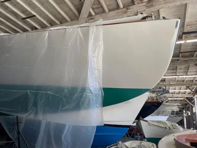 Slide: The Image of Herreshoff 42 sailboat from 2003 in a boatyard, partially covered with plastic sheeting. - 13