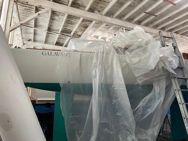 Slide: The Image of Herreshoff 42 sailboat from 2003, partially covered, in a workshop setting. - 14