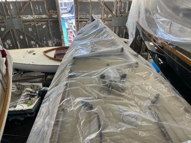 Slide: The Image of Herreshoff 42 sailboat from 2003, covered in plastic, stored indoors. - 2