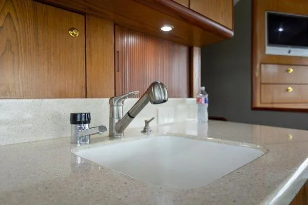 Slide: The Image of Kitchen sink area in 2008 Ocean Yachts 46SS, featuring wooden cabinets and modern fixtures. - 13