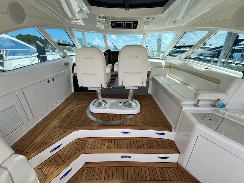 Slide: The Image of 2010 Sea Ray 540 Sundancer cockpit with white seating and wooden flooring. - 10