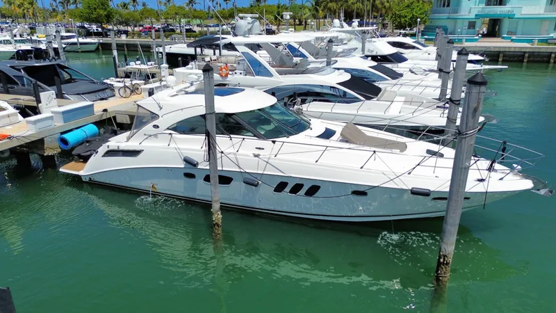 Slide: The Image of 2010 Sea Ray 540 Sundancer yacht docked in a marina, surrounded by other boats. - 2