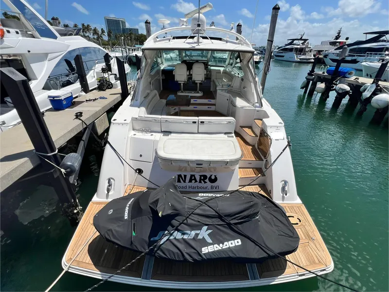 Slide: The Image of 2010 Sea Ray 540 Sundancer docked with jet ski on platform, sunny marina setting. - 5