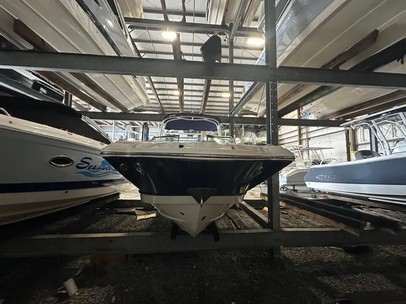 Slide: The Image of 2018 Chaparral 244 Sunesta boat stored in a marina rack, surrounded by other boats. - 14