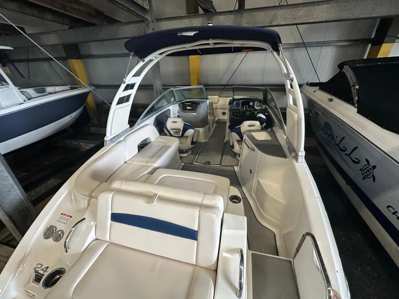 Slide: The Image of 2018 Chaparral 244 Sunesta boat with white seating and blue accents in storage. - 17