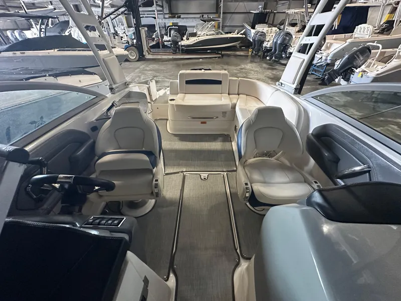 Slide: The Image of 2018 Chaparral 244 Sunesta boat interior with seating and steering wheel in a showroom. - 20