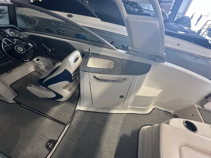 Slide: The Image of 2018 Chaparral 244 Sunesta boat interior with steering wheel and seating area. - 21