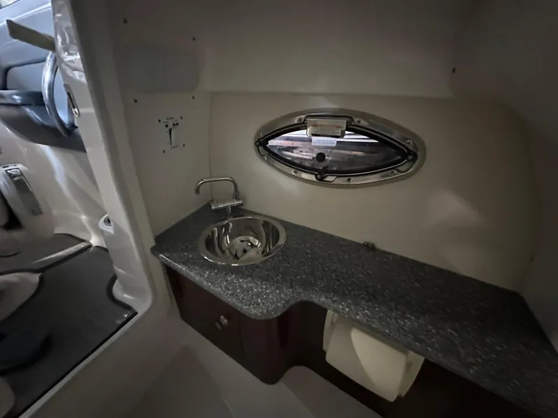 Slide: The Image of 2018 Chaparral 244 Sunesta boat interior with sink and porthole window. - 30