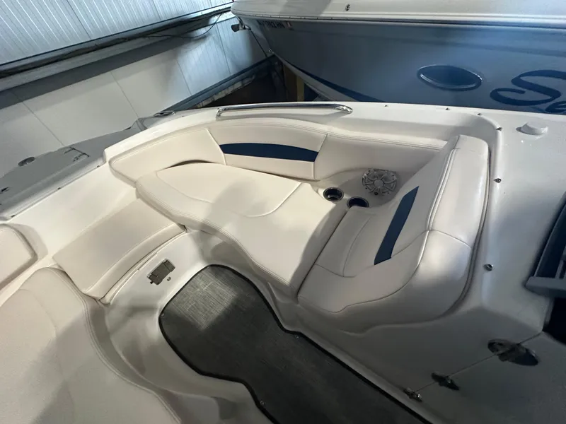 Slide: The Image of 2018 Chaparral 244 Sunesta boat interior with white seating and blue accents. - 37