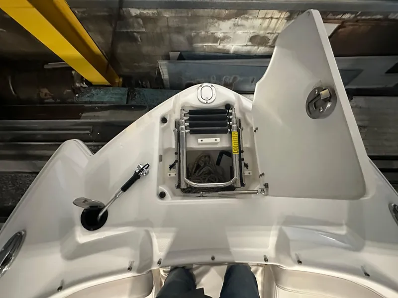 Slide: The Image of 2018 Chaparral 244 Sunesta boat deck with open storage compartment and ladder. - 39