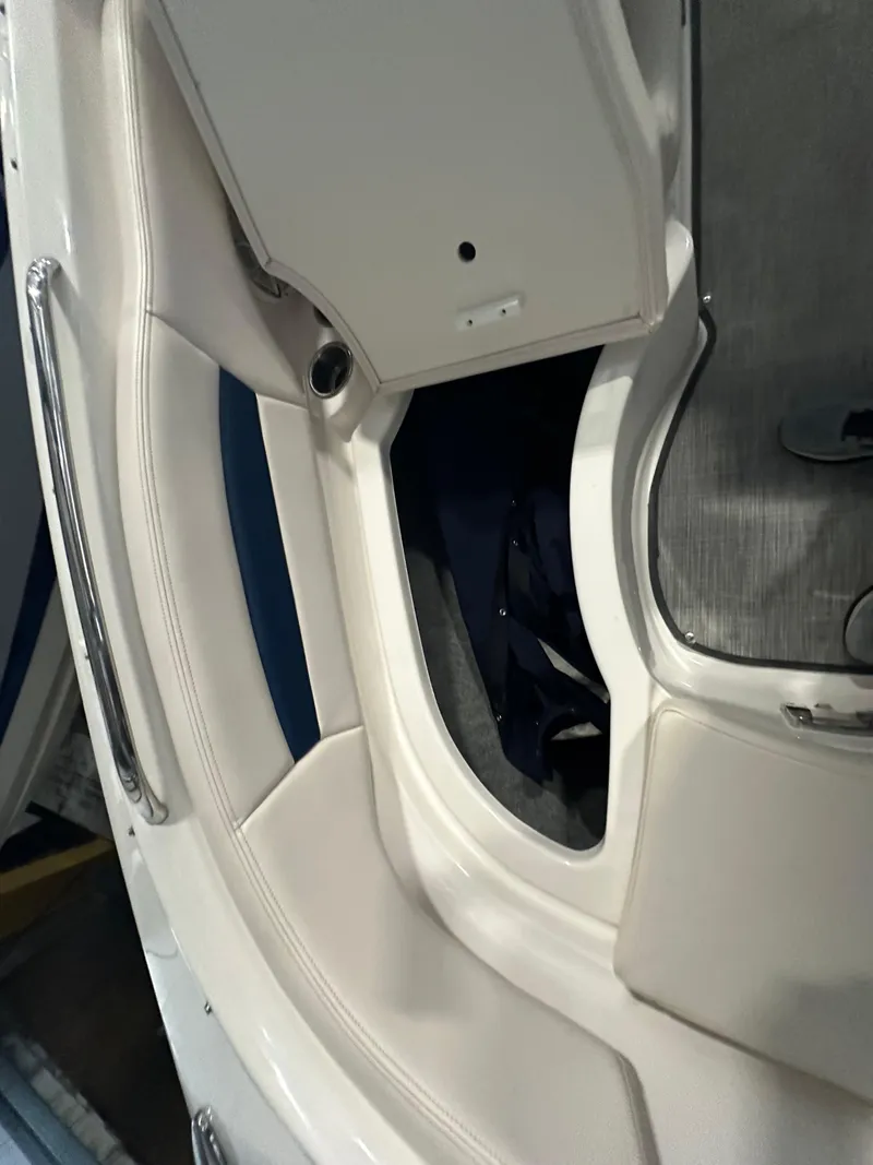 Slide: The Image of 2018 Chaparral 244 Sunesta boat interior with white seating and storage compartment. - 41
