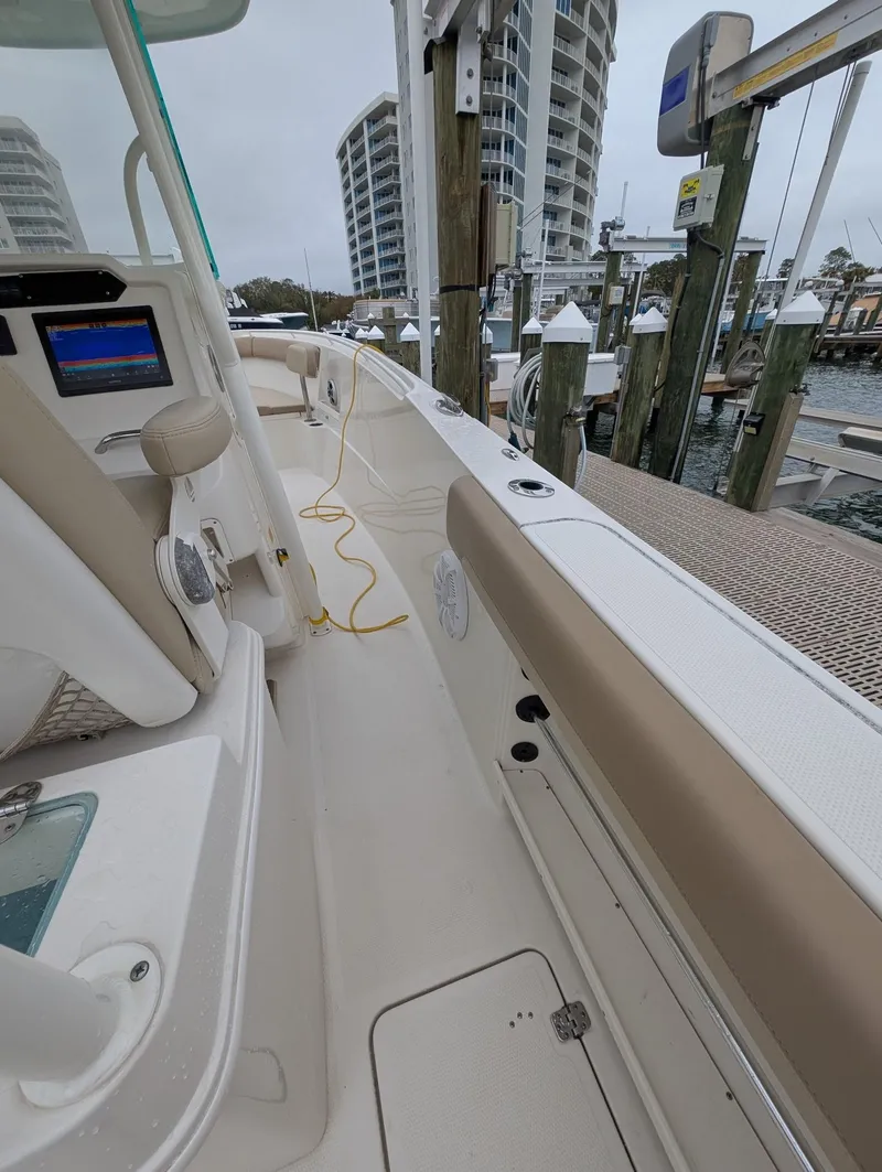 Slide: The Image of 2019 Sailfish 290cc boat docked at marina with modern interior and cityscape background. - 13