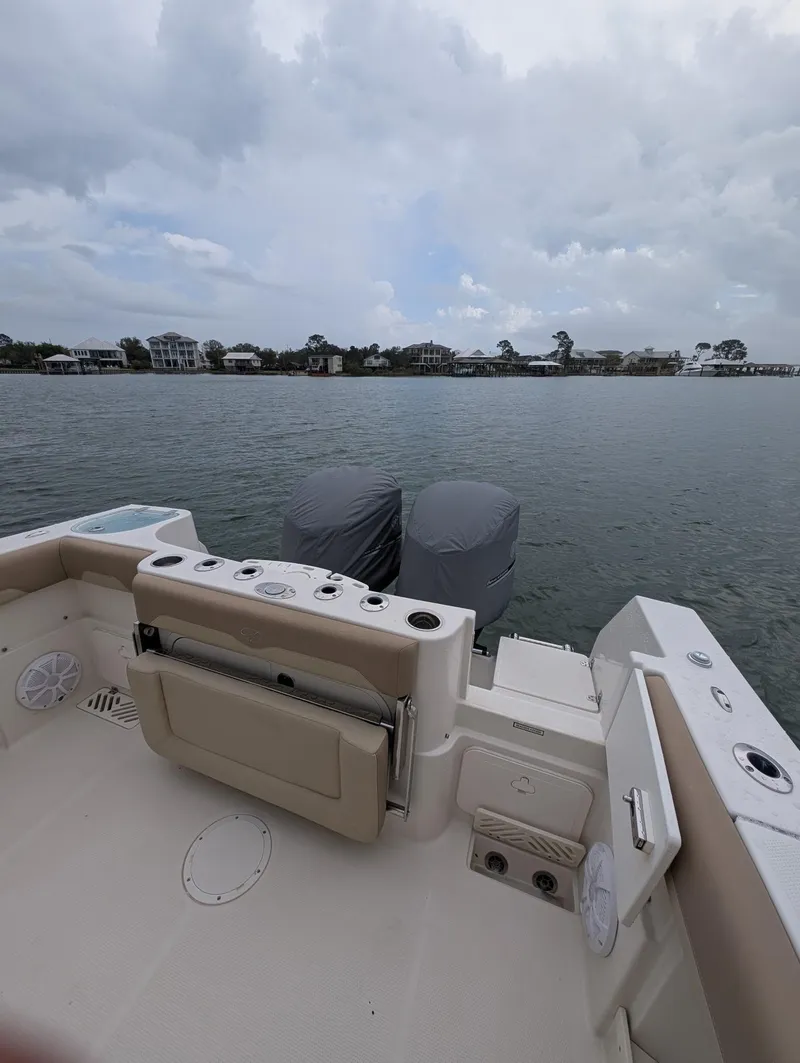 Slide: The Image of 2019 Sailfish 290cc boat on calm water, featuring dual engines and spacious deck. - 5