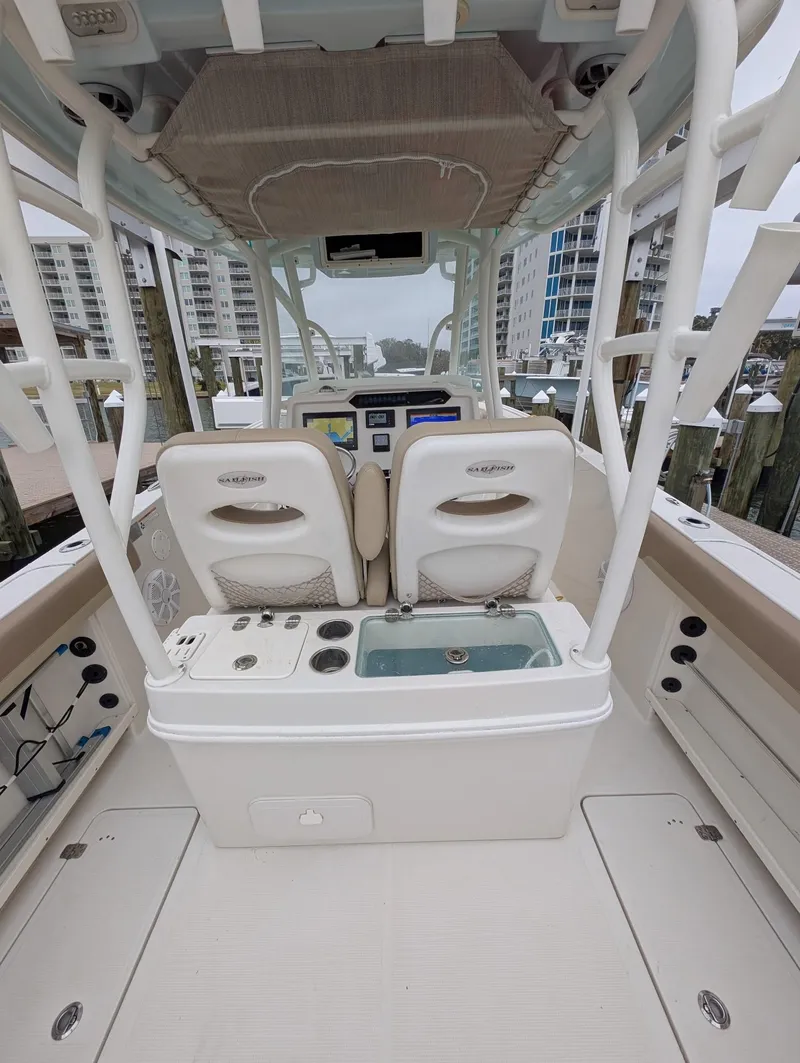Slide: The Image of 2019 Sailfish 290cc boat interior with dual seats, control panel, and cityscape background. - 9