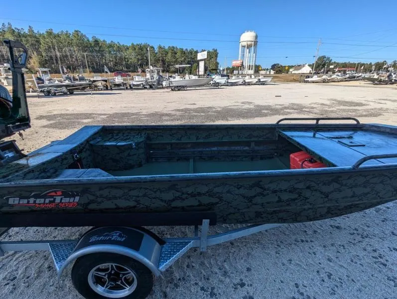 Slide: The Image of 2025 Gator Tail 1750 Savage Series boat on trailer in a marina setting. - 5