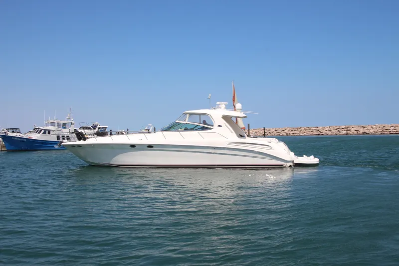 Slide: The Image of 2003 Sea Ray 550 Sundancer yacht cruising on calm waters under a clear blue sky. - 0