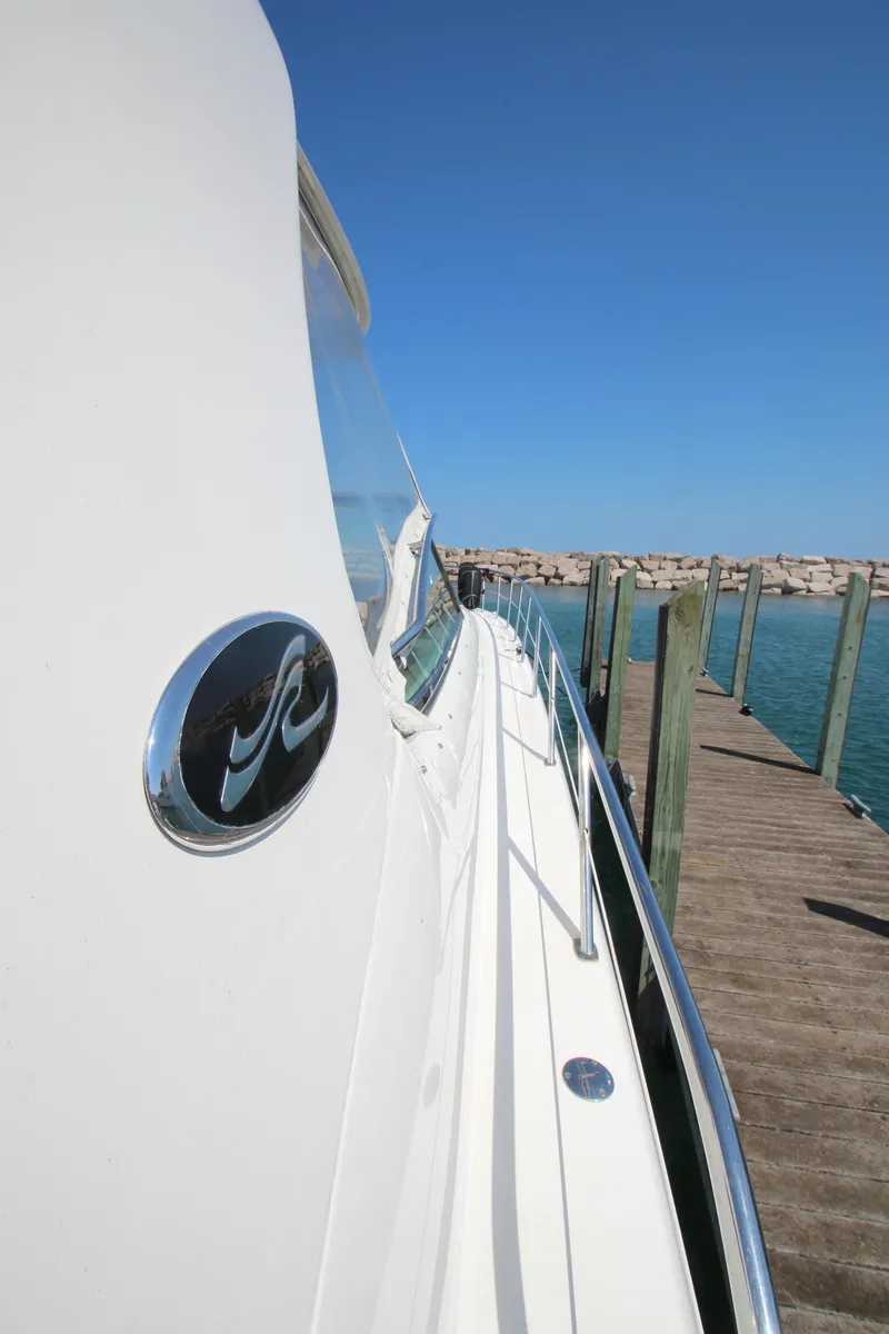 Slide: The Image of 2003 Sea Ray 550 Sundancer yacht docked, showcasing sleek design and ocean backdrop. - 11