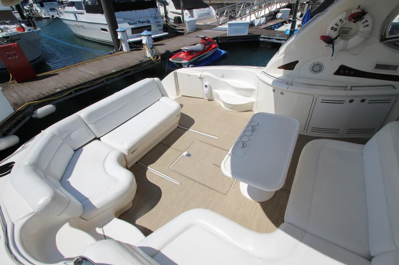 Slide: The Image of 2003 Sea Ray 550 Sundancer yacht with spacious seating and table at marina. - 12