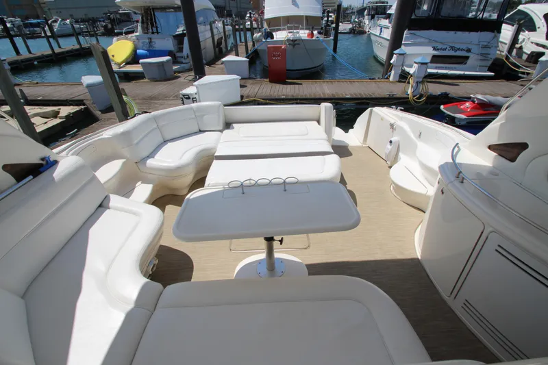 Slide: The Image of 2003 Sea Ray 550 Sundancer yacht interior with spacious seating and table at marina. - 18