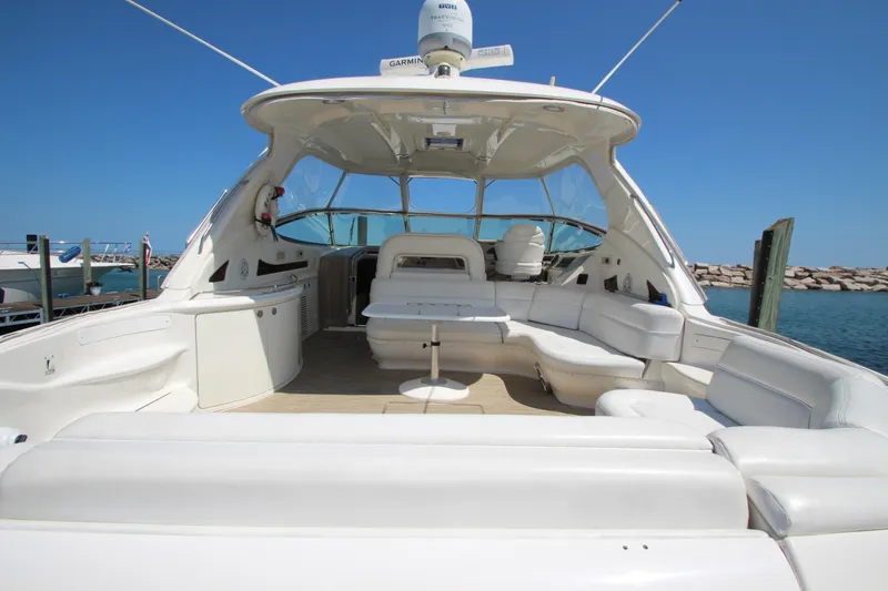 Slide: The Image of 2003 Sea Ray 550 Sundancer yacht with spacious deck and seating, docked by the water. - 2
