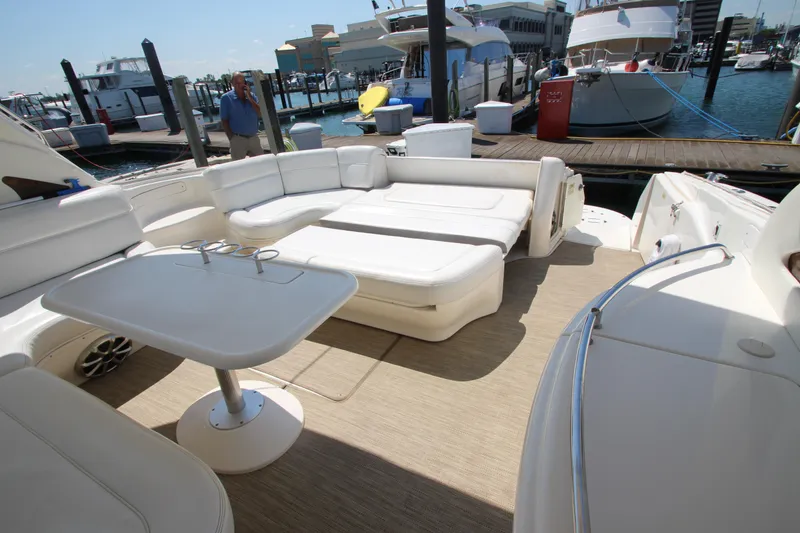Slide: The Image of 2003 Sea Ray 550 Sundancer yacht with spacious deck seating and table at marina. - 20