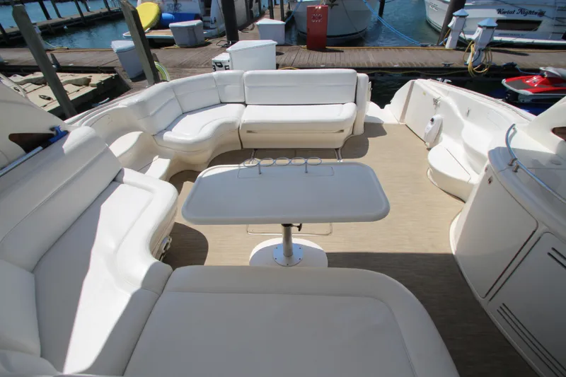 Slide: The Image of 2003 Sea Ray 550 Sundancer yacht with spacious white seating and table on deck. - 21
