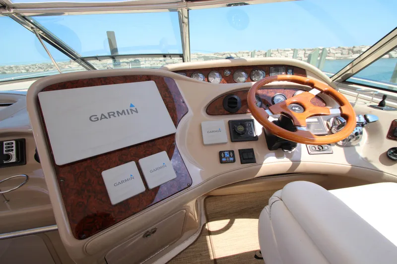 Slide: The Image of 2003 Sea Ray 550 Sundancer helm with Garmin navigation system and wooden steering wheel. - 28