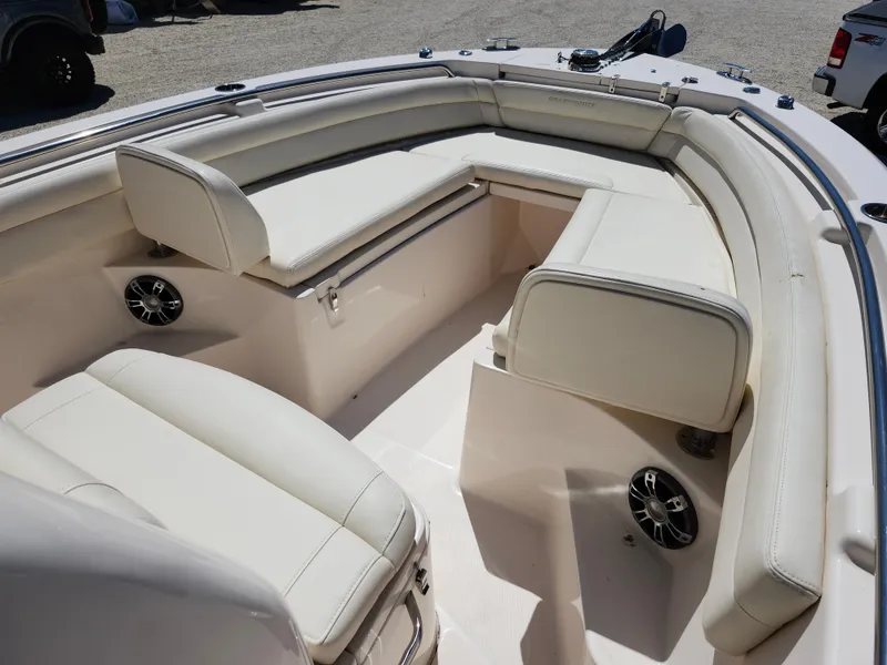 Slide: The Image of 2021 Grady-White Fisherman 236 boat interior with white cushioned seating and speakers. - 2