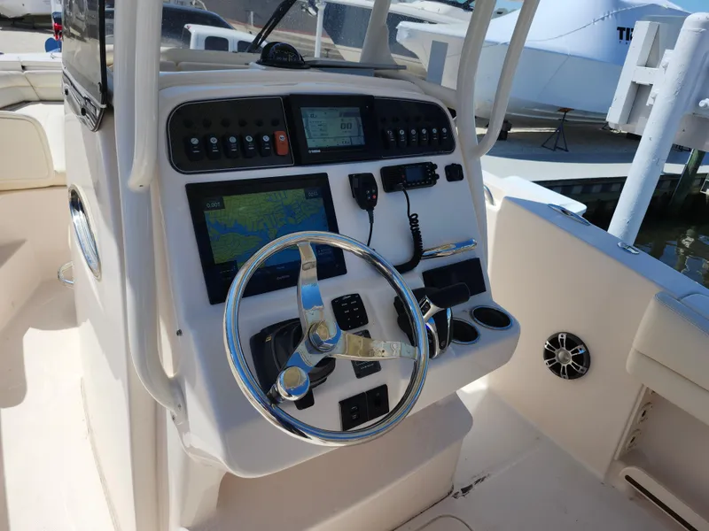 Slide: The Image of 2021 Grady-White Fisherman 236 boat dashboard with steering wheel and navigation controls. - 5