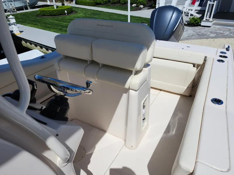 Slide: The Image of 2021 Grady-White Fisherman 236 boat interior with cushioned seating and steering wheel. - 7