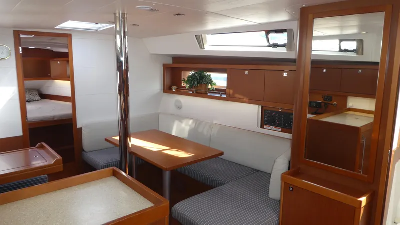 Slide: The Image of Interior of 2014 Beneteau Oceanis 41 sailboat with dining area and cozy cabin. - 10